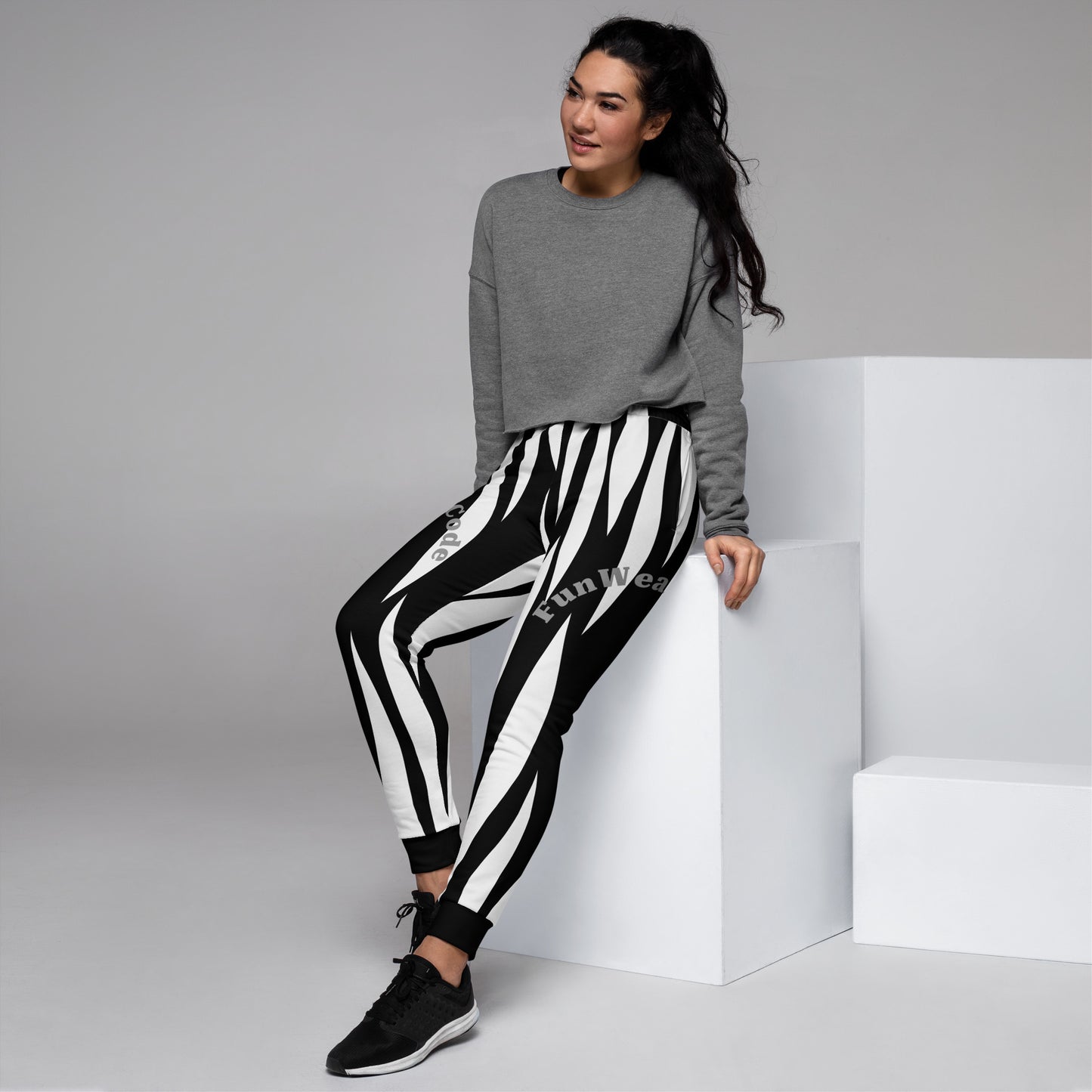 Woman wearing a gray sweatshirt and black and white striped sweatpants with a 'Fun Wear Code' logo on a gray background