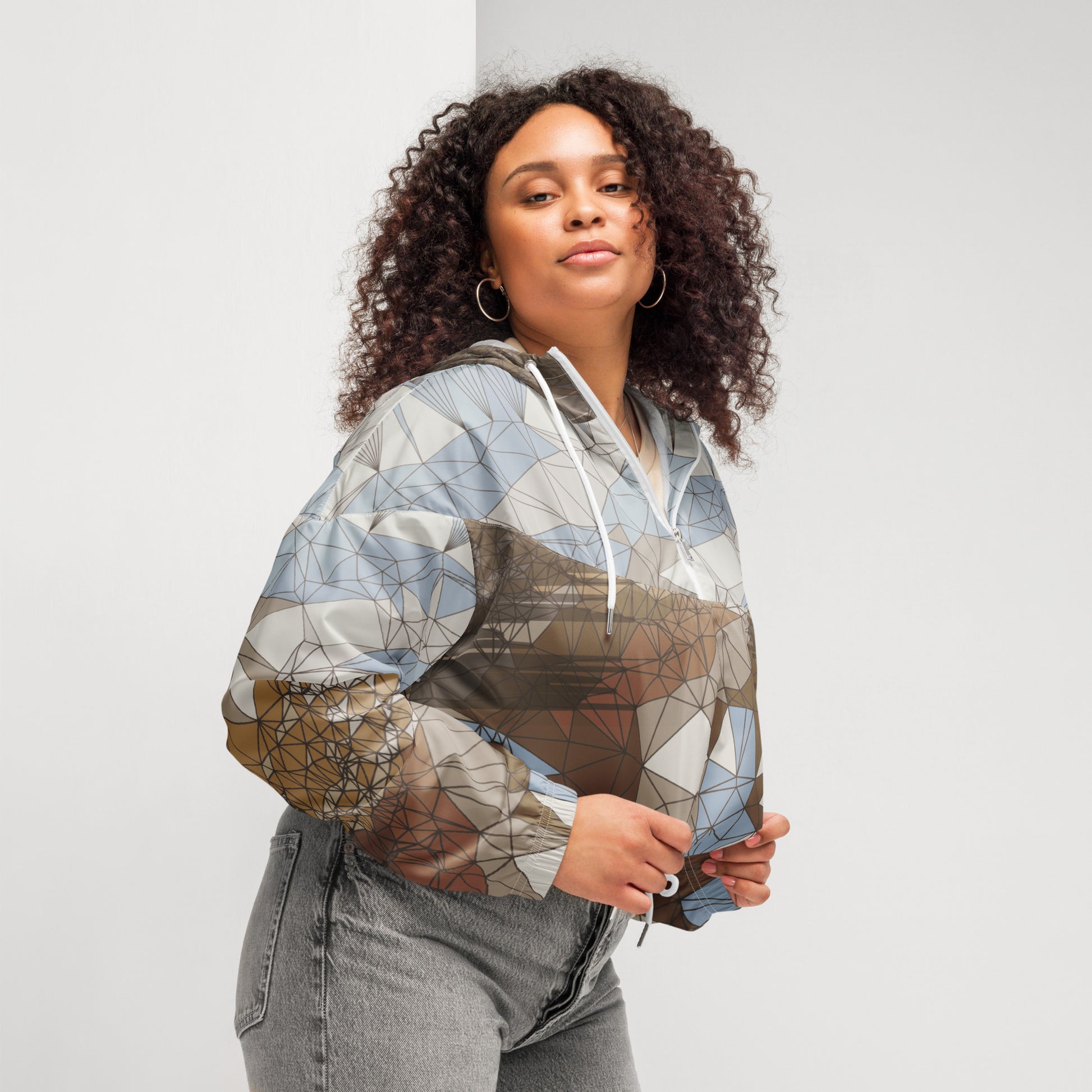 Woman wearing a geometric patterned windbreaker against a plain background