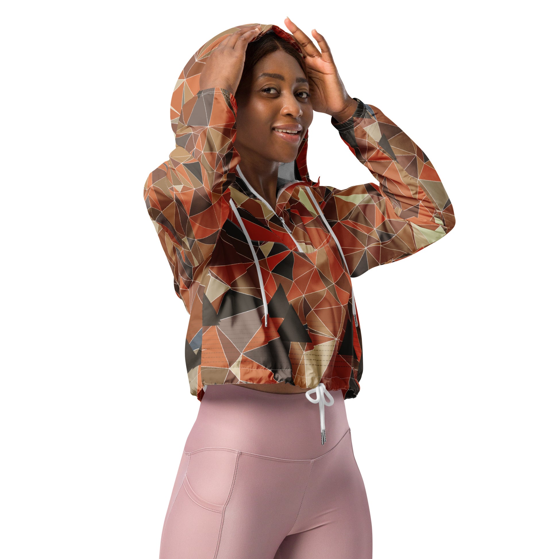 Woman wearing a cropped multicolor geometric patterned windbreaker jacket and pink leggings on a white background